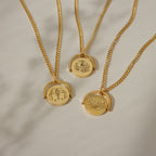 The Zodiac Spinner Necklace features three gold necklaces with round pendants, each showcasing a unique line art or astrological design—ideal for personalized engraving or as a Zodiac-inspired accessory.