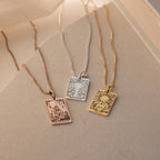 Three Tarot Necklace in Box Chain pieces from the Major Arcana collection—gold, silver, and rose gold—are displayed on a neutral surface.