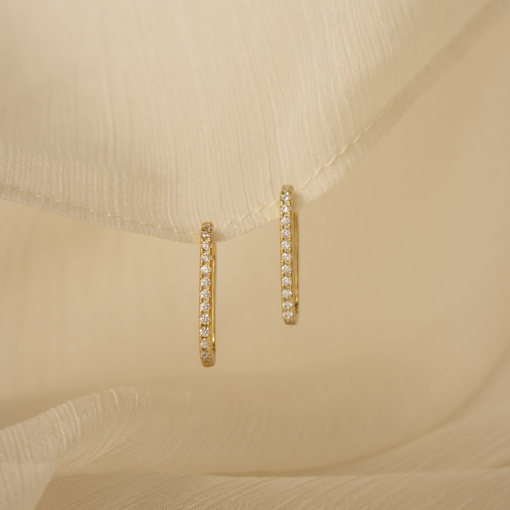 Pave Link Earrings with sparkling diamonds featured on soft, cream-colored fabric.