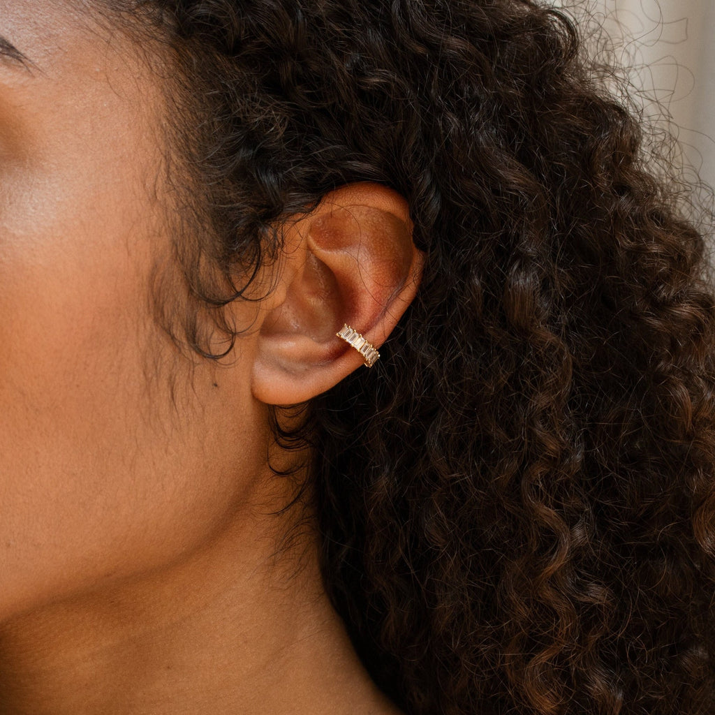 Close-up of a person with curly hair wearing Baguette Ear Cuffs on the upper part of their ear.