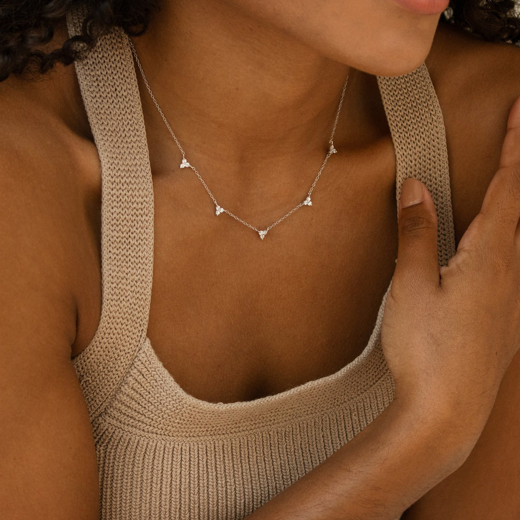 Woman wearing a beige knit tank top and the Hana Diamond Station Necklace, a delicate silver layering piece adorned with small triangle pendants.