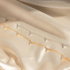The Hana Diamond Station Necklace, delicately crafted, is displayed on soft, shimmering beige fabric.