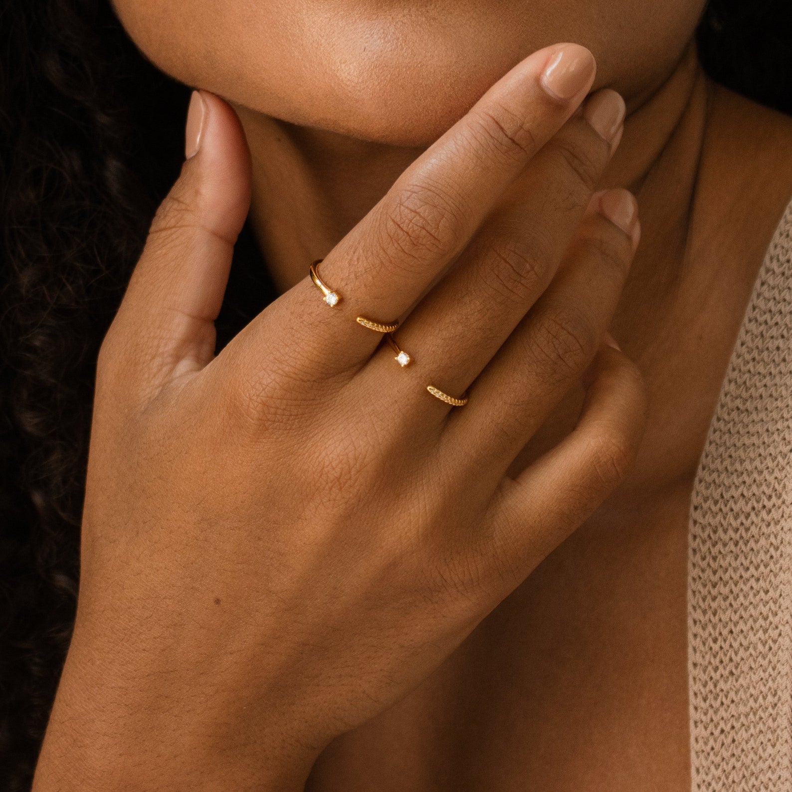A manicured hand, wearing the Cecilia Pave Ring and an open-style ring, gently touches the chin.