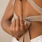 A hand wearing the Lace Pave Ring holds a beige knitted strap on an open-back top.