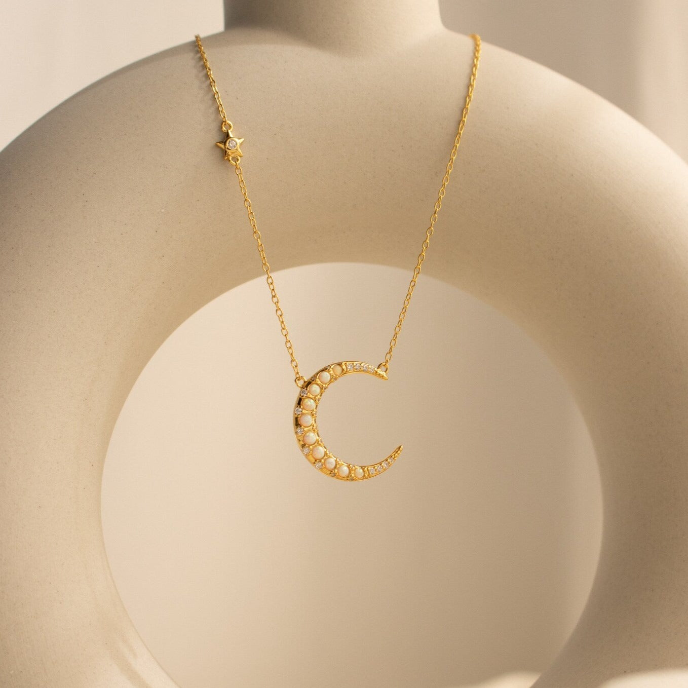 Opal Crescent Moon Necklace featuring a small star charm, displayed on a curved ceramic stand—a perfect boho accessory for celestial-inspired style.