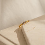 The Lace Pave Ring is displayed on a beige textured surface under soft lighting.