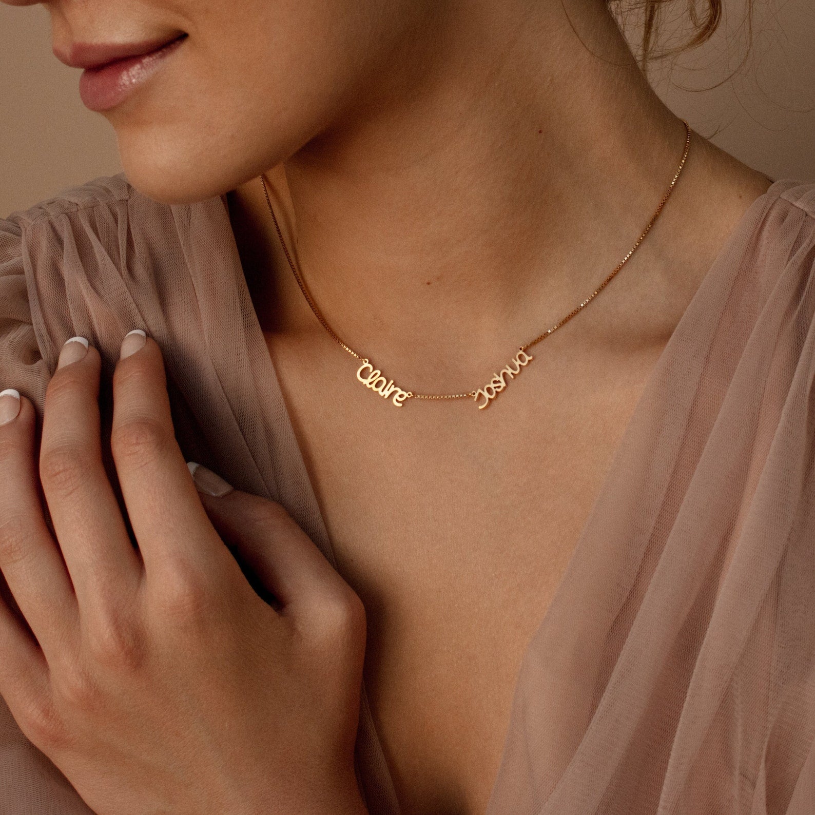 Woman wearing a sheer beige top and the Preppy Multiple Name Necklace in Box Chain with "Claire" and "Sophie" in a youthful font—perfect personalized jewelry for any occasion.
