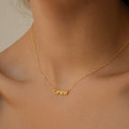 The Tiny Preppy Name Necklace, shown worn by a woman from the shoulders up with "Cameron" in a youthful font, is fully customizable with any name of your choice.