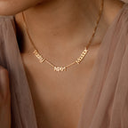 The Preppy Multiple Name Necklace in Box Chain, shown in gold with the names Paisley, Aspen, and Maddox in a youthful font, is styled here with a sheer top.