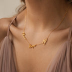 Close-up of a woman's neck wearing the Nella Multiple Name Necklace in gold, featuring the names Olivia, Harper, and Ella.