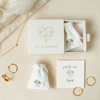 Minimalist jewelry in white pouches and box, featuring gold rings, the Callie Box Chain Name Necklace in 18K Gold, and a "just for you!" card. Enjoy!.