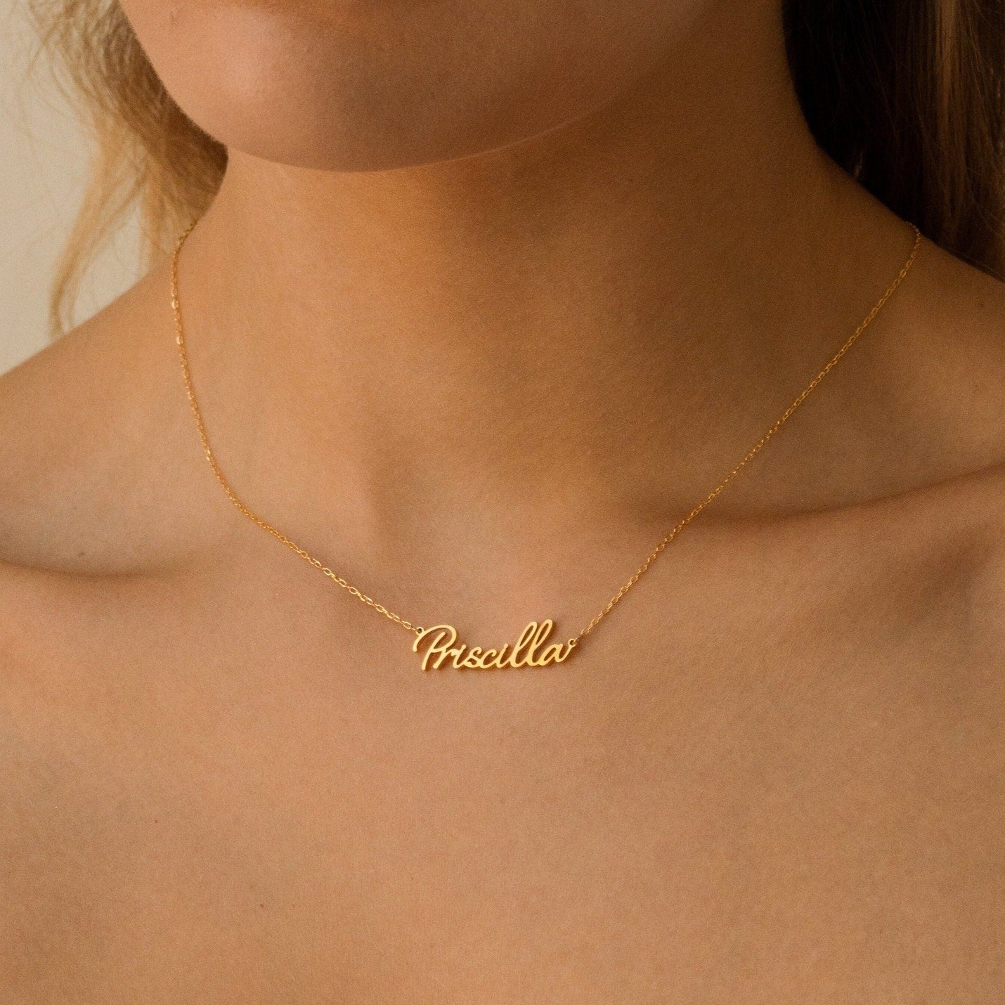Grace Name Necklace with "Priscilla" in elegant cursive, worn by a woman with bare shoulders—a beautiful personalized piece and heartfelt custom nameplate.