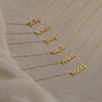 Seven Grace Name Necklaces displayed on a beige surface, each personalized with a different name in elegant cursive script.