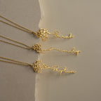 Three gold Flower Name Necklaces, each with a unique floral design and personalized with the names Sarah, Emily, and Payton plus their birth flowers, are displayed on a neutral background.
