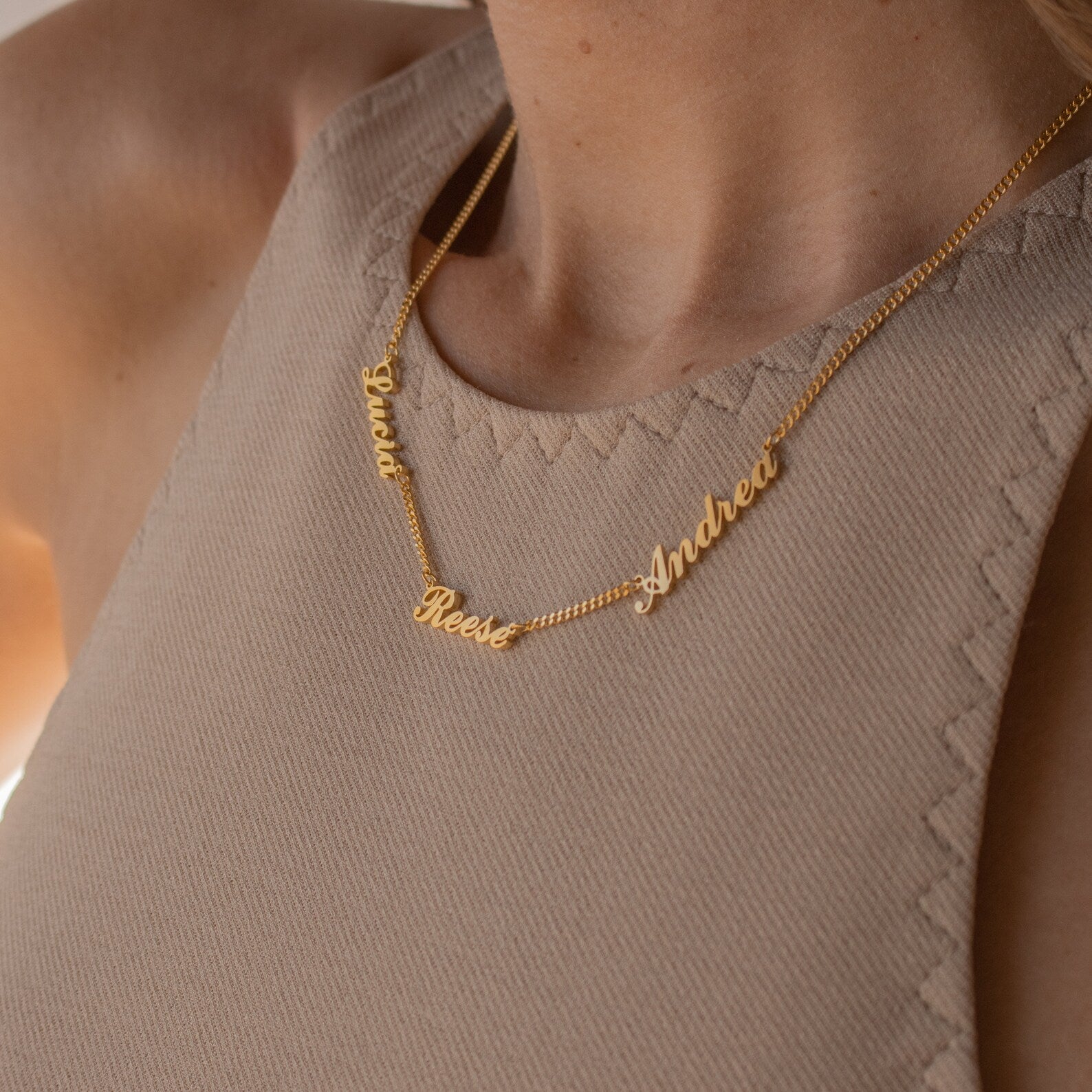 Close-up of a woman wearing the Carrie Multiple Name Necklace in Curb Chain, a personalized piece featuring the names Reese, Andrea, and Gina in elegant script.