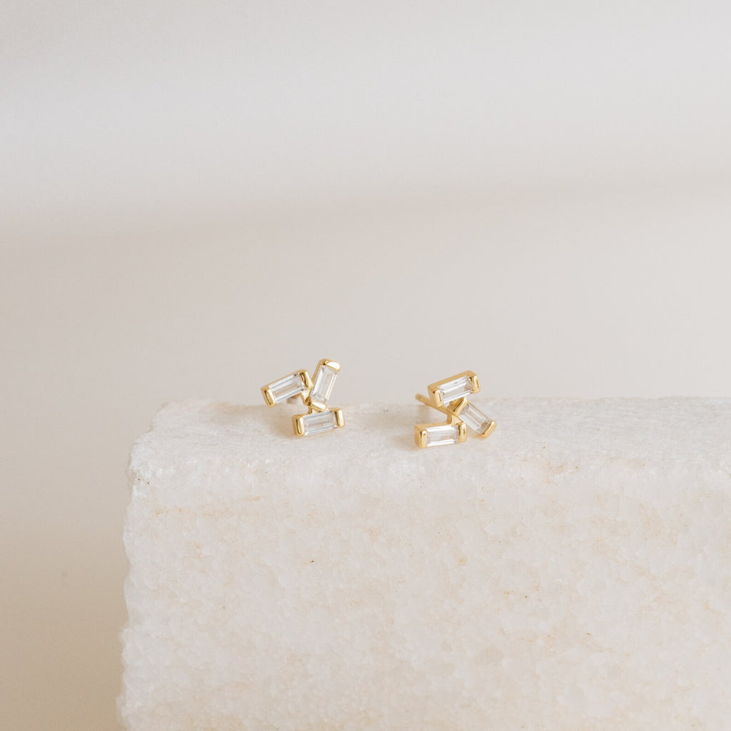 Glacier Diamond Studs showcased on a textured white stone surface with a neutral background.