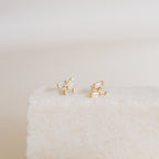Glacier Diamond Studs showcased on a textured white stone surface with a neutral background.
