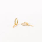 The Quinn Pave Dagger Huggies are gold diamond earrings, perfect for adding subtle elegance to any look.