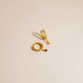 The Emily Pave Star Huggies feature gold hoops with star charms and embedded crystals, creating a celestial sparkle against a light beige background.