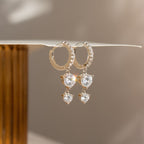 Caroline Pave Drop Huggies feature gold hoops adorned with teardrop-shaped crystals that sparkle in natural light, adding a touch of elegance to any look.