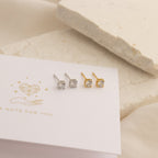 The Booker Large Diamond Studs come in two pairs—one silver, one gold—arranged on a decorative card. Ideal for everyday wear, these minimal studs suit any style.