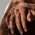 A hand with manicured nails and delicate jewelry showcases the Pave Open Circle Ring, highlighted by soft shadows on the skin.