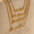 Four gold Mellow Name Necklaces in Curb Chain with name pendants—London, Analicia, Heather, and Amanda—are displayed on a beige surface. This personalized jewelry showcases timeless elegance in a classic font style.