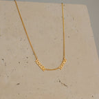 Preppy Multiple Name Necklace in Curb Chain shown on a stone background, featuring the cursive names "Resil" and "Darey" in a youth-inspired font, elegantly connected by a thin curb chain.