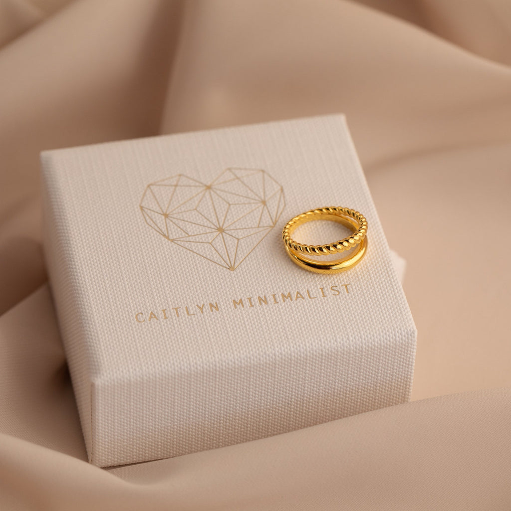 Chelsea Duo Ring in gold displayed on Caitlyn Minimalist branded jewelry box with neutral fabric background.