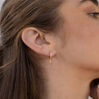 A close up of a woman's ear adorned with Emily Pave Star Huggies.