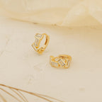 Glacier Baguette Huggies with rectangular white stones add minimalistic sparkle, shown on a light textured surface against a soft background.