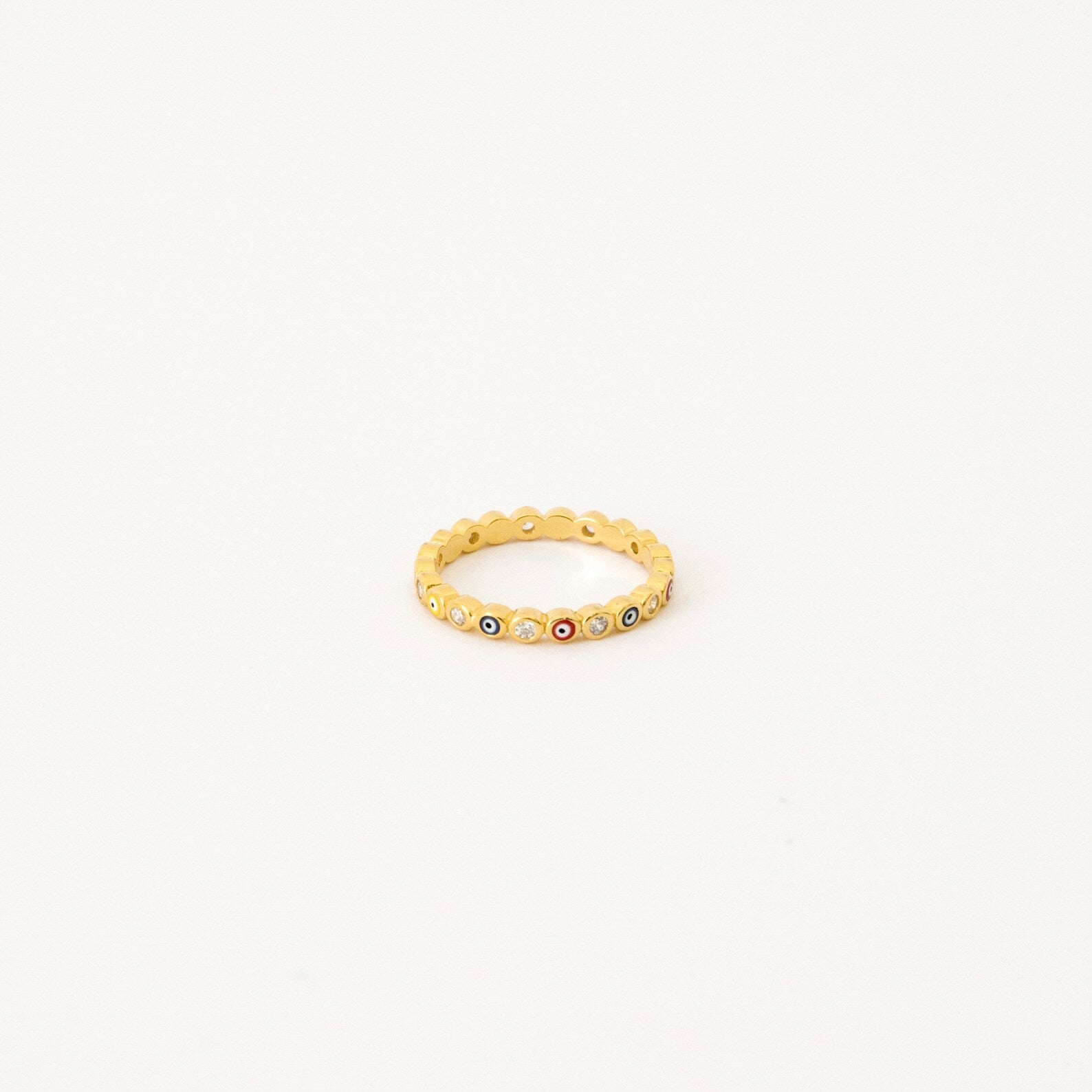 The Rainbow Evil Eye Ring features multicolored gemstones set around the band, bringing a vibrant twist to classic evil eye jewelry. Displayed on a white background, this lucky charm ring adds bold protection to any style.