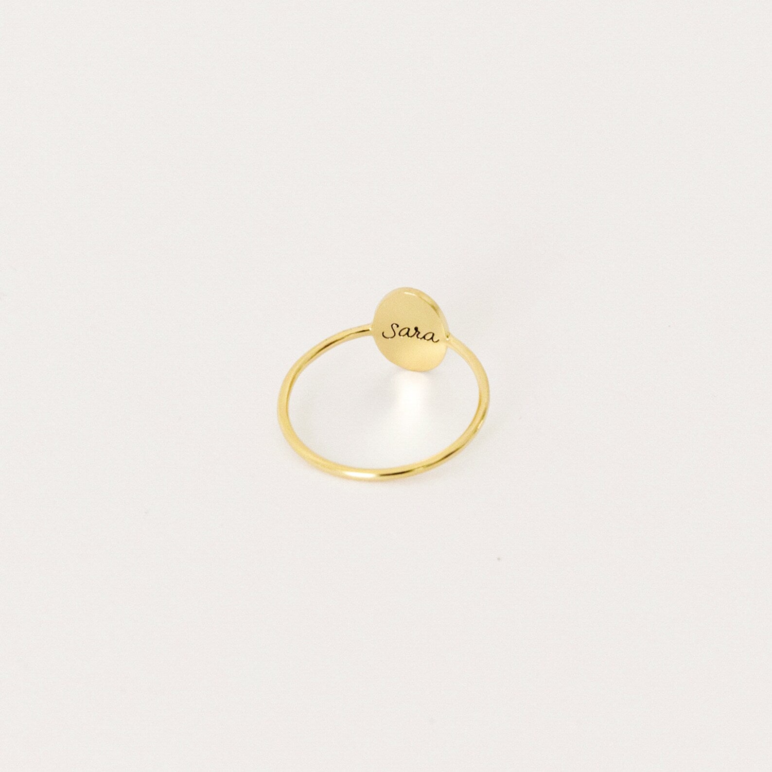 The Flower Oval Ring features a small, oval engraved plate reading "Sara," captured against a plain white background—a perfect personalized jewelry piece for a meaningful touch.