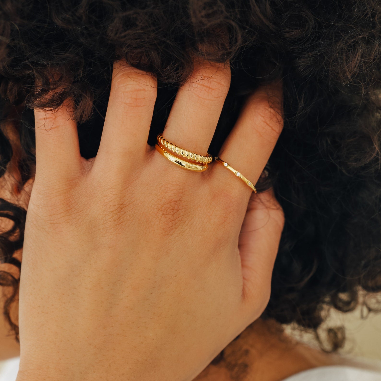Chelsea Duo Ring in gold styled on hand through hair, stacked with a thin diamond ring.