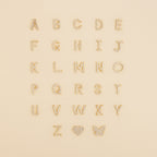 The Pave Initial Heart Necklace features gold, diamond-studded alphabet letters and a heart charm—ideal for creating your own custom initial or handmade diamond necklace.