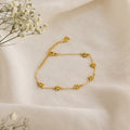 The Flower Child Bracelet features delicate gold star charms on soft cream fabric with small white flowers—a whimsical accessory for your cottage-core style.