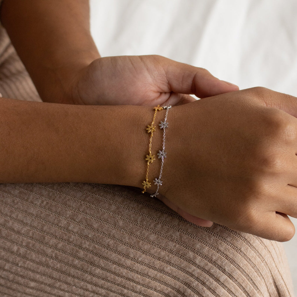 The Flower Child Bracelet features two delicate star charm bracelets—one gold, one silver—that adorn your wrist, perfect for the boho-hippie soul or anyone seeking an enchanting accessory.