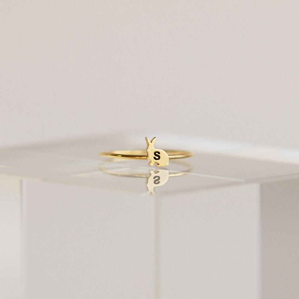 Pet Initial Ring with a small bunny-shaped charm featuring the letter S, presented on a clear minimalist stand—ideal personalized jewelry for pet lovers.