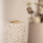 Evermore Diamond Band in 18K gold with pave-set diamonds on textured neutral background.