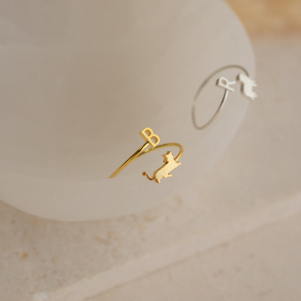The Duo Pet Initial Wrap Ring in Sterling Silver features two delicate rings with cat silhouettes and initials—ideal personalized jewelry for cat lovers or anyone seeking custom pet accessories.