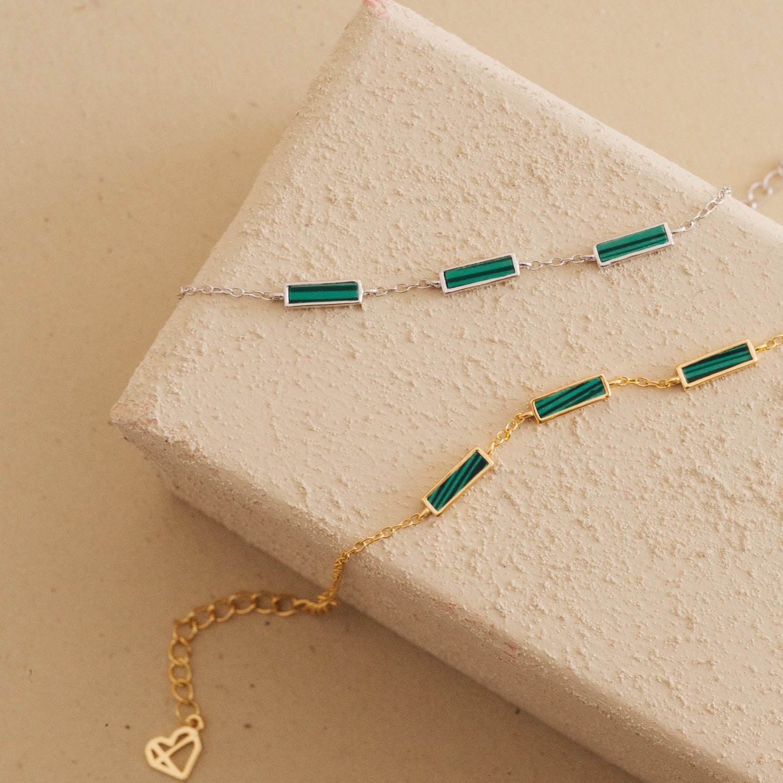 The Malachite Bar Bracelet, available in silver and gold with green rectangular stones, features a dainty chain design. Perfect for stacking or wearing solo, this handmade piece adds a subtle boho touch to any look.