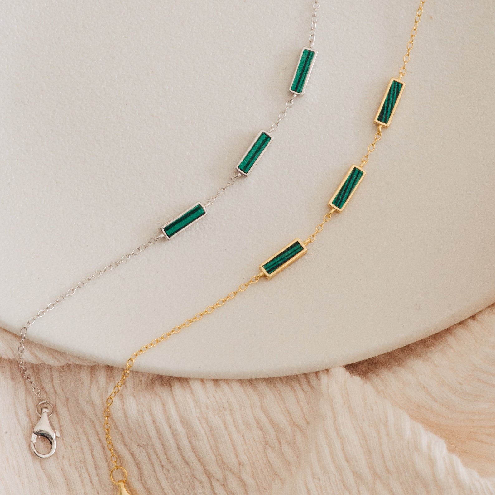 The Malachite Bar Bracelet, available in gold and silver chains with green rectangular malachite beads, offers a boho handmade style perfect for any neutral backdrop.