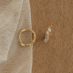 Pair of Sprinkle Diamond Huggies resting on fabric