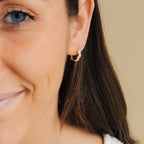 Model wearing gold Sprinkle Diamond Huggies while smiling