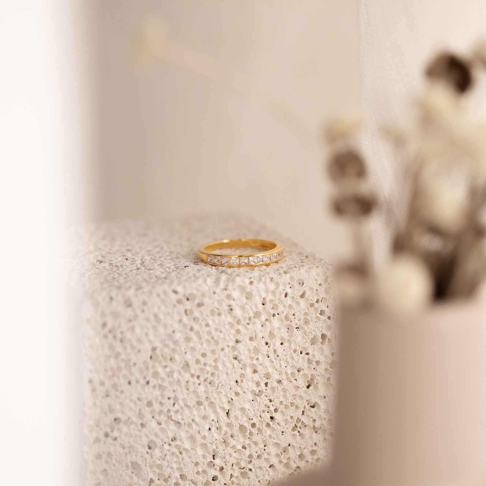 Evermore Diamond Band in 18K gold with pavé diamond setting on textured stone surface.