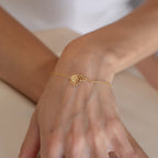 The Custom Flower Bracelet, a delicate gold lotus design, makes a perfect personalized graduation gift and shines beautifully on the wrist against a light background.