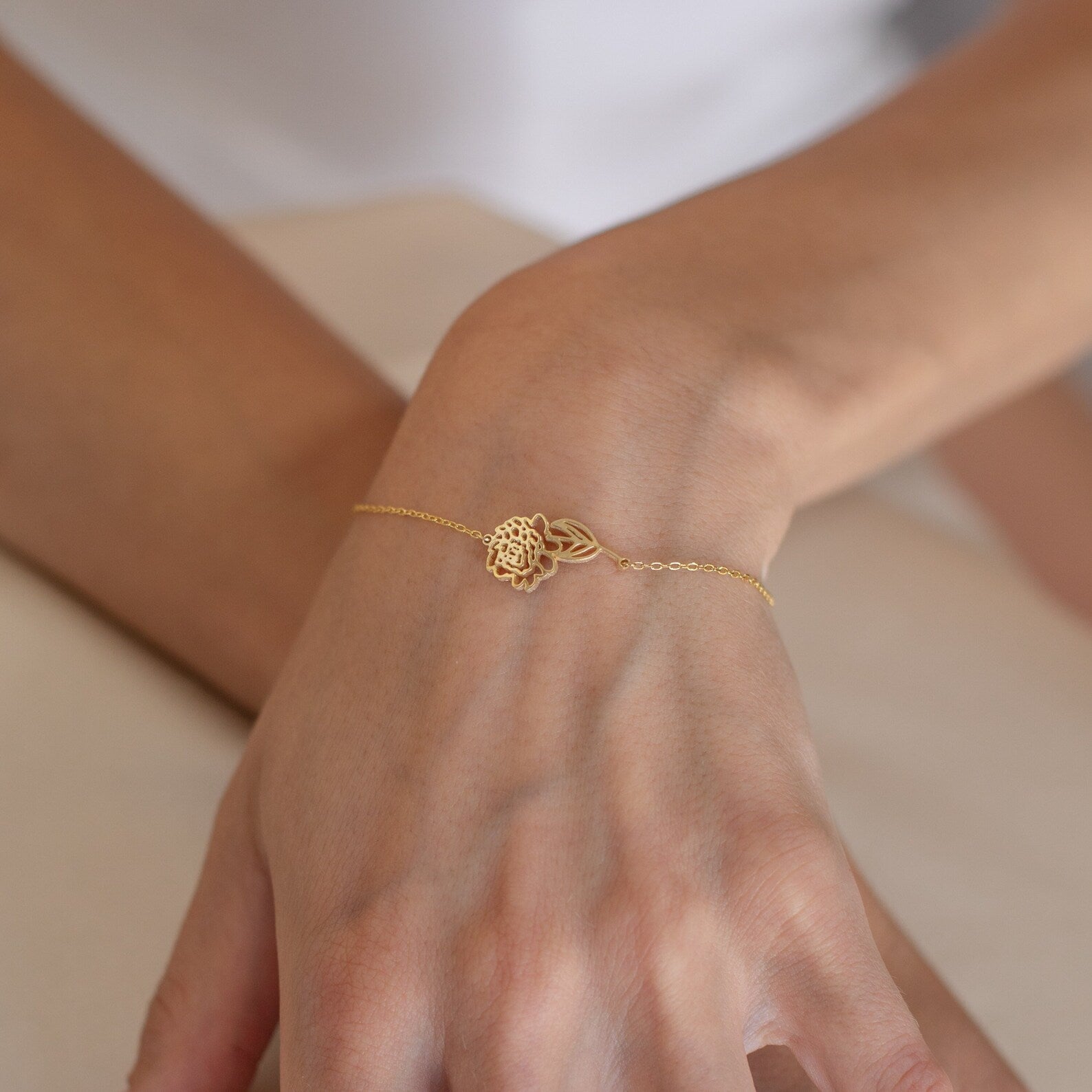 The Custom Flower Bracelet, a delicate gold lotus design, makes a perfect personalized graduation gift and shines beautifully on the wrist against a light background.