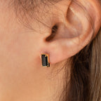 Close-up of an ear wearing Rectangle Black Onyx Studs, showcasing the chic black and gold earrings.