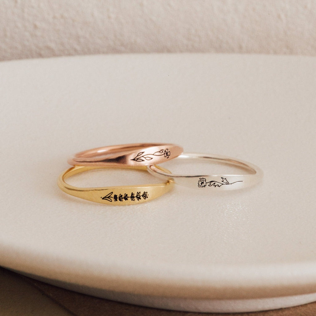 The Skinny Flower Ring in Rose Gold features a delicate engraved botanical design—perfect for stacking with other minimalist bands.