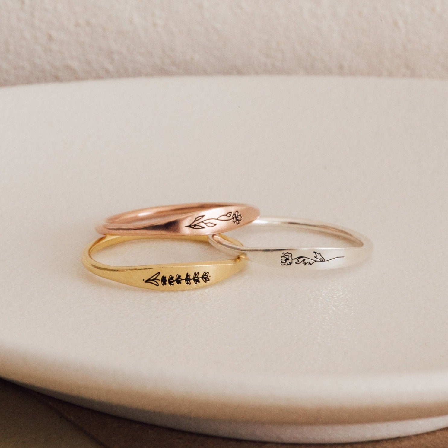 The Skinny Flower Ring in Rose Gold features a delicate engraved botanical design—perfect for stacking with other minimalist bands.